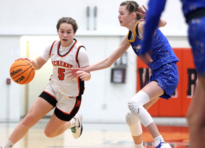 McHenry’s Gaby Grasser, left, hustles past Johnsburg’s Skye Toussaint in varsity girls basketball on Saturday, Jan. 4, 2025, at McHenry High School in McHenry.