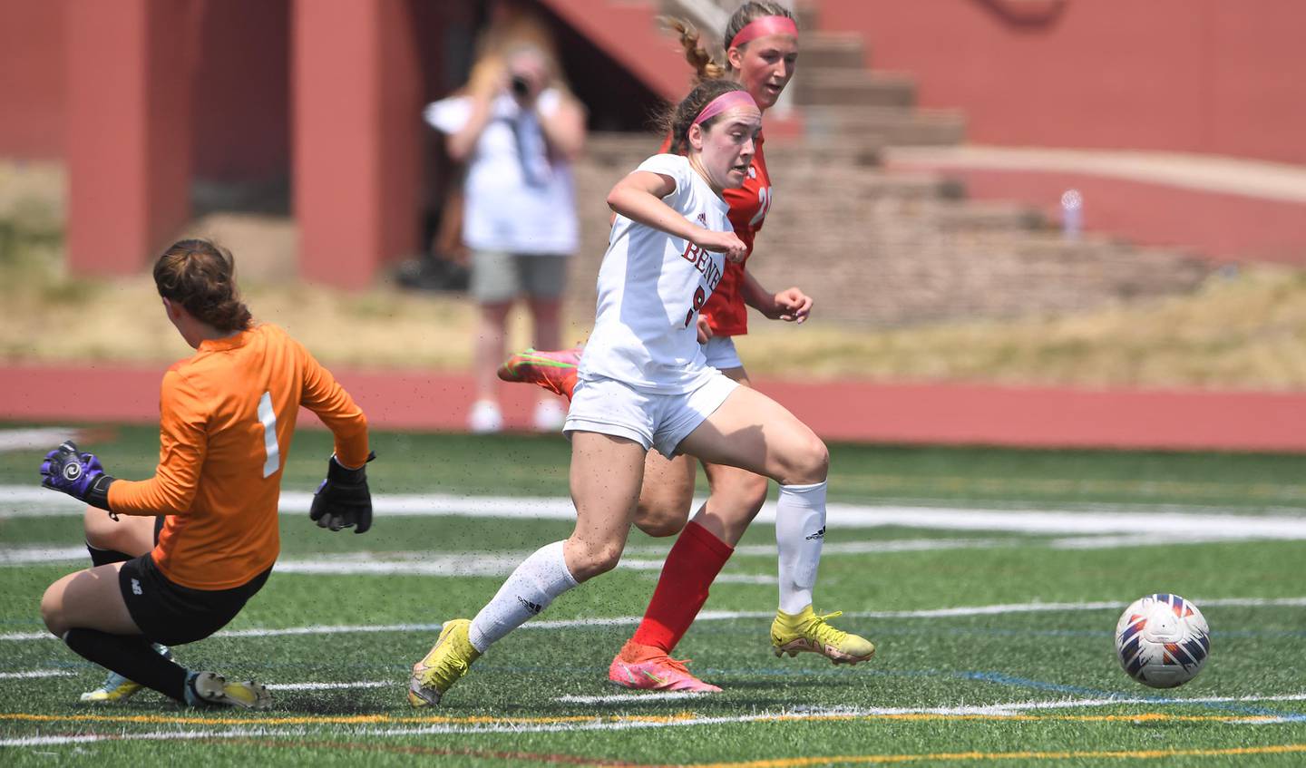 Benet Academy’s Keira Petrucelli gets past Glenwood goalkeeper Abi Stephens but loses the ball to a defensive kick from Haden Vlcek, background, in the IHSA girls Class 2A state soccer championship game at North Central College in Naperville on Saturday, June 3, 2023.
