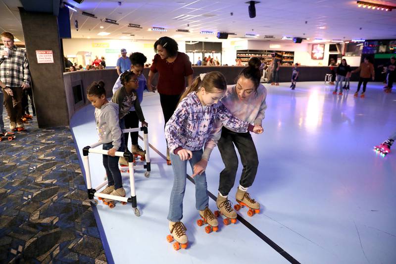 Angela Rossi of St. Charles helps her daughter, Aliya, 9, rollerskate during a winter break open skate session at Funway in Batavia.