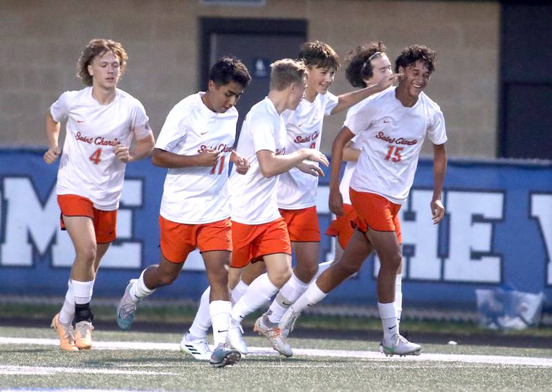 St. Charles East players celebrate a goal by teammate Brandon Pinto (far right) during a game at Geneva on Tuesday, Oct. 3, 2023.