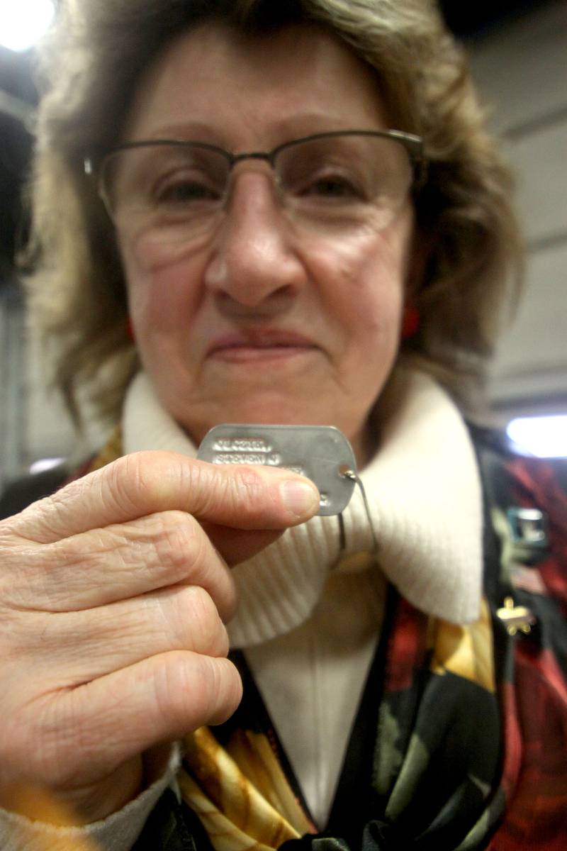 Mary Olczyk of Carol Stream displays her husband’s dog tags during a remembrance Saturday at Wonder Lake Fire Protection District Station 2 on the 40th anniversary of a midair military jet explosion that happened over the small, rural area northeast of Woodstock. Olczyk’s husband and 26 others lost their lives as the plane exploded midair at 9:11 p.m., its flaming pieces raining over a 2-mile area near Greenwood.