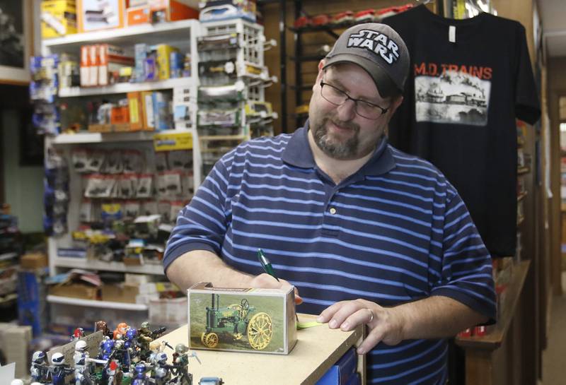 Matt Drennan, owner of M.D. Trains, prices a die-cast car Friday Aug. 19, 2022, in his store at 130 Cass St. in Woodstock, in preparation for this past weekend's exhibit at the Woodstock Square car show. The model train and die-cast car shop has been fixture on the Woodstock Square for a few years and draws visitors in to check out the rotating display of trains in the front window.