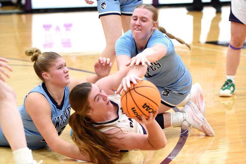 Manteno's Emily Horath, center, looks to pass after beating Cissna Park's Ava Henrichs, left, and Addison Lucht to a loose ball during a game at Manteno Monday, Jan. 19, 2026.