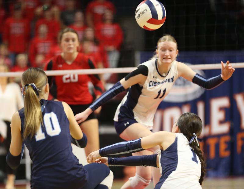 Cissna Park players Kendyl Neukomm, Ella Schluter dig out a return from Calhoun as teammate Sophia Duis looks on during the Class 1A State semifinal game on Friday, Nov. 15, 2024 at CEFCU Arena in Normal.