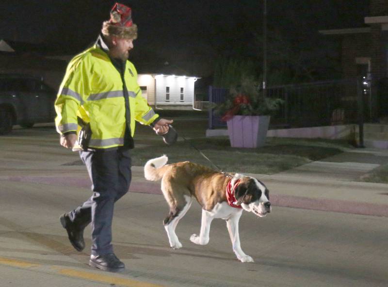 Haven, walks in the parade with her handler Peru Police officer Brian Zebron during the annual Christmas Parade on Saturday, Dec. 7, 2024 on Peoria Street in Peru.