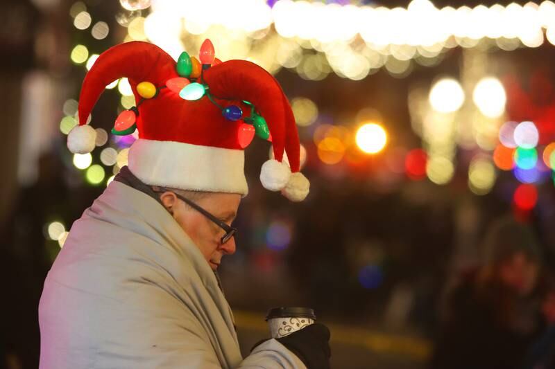 Sean Flanagan of Crystal Lake stays bundled up while sipping a warm drink during the Festival of Lights Holiday Parade in downtown Crystal Lake on Friday, Nov. 29, 2024.