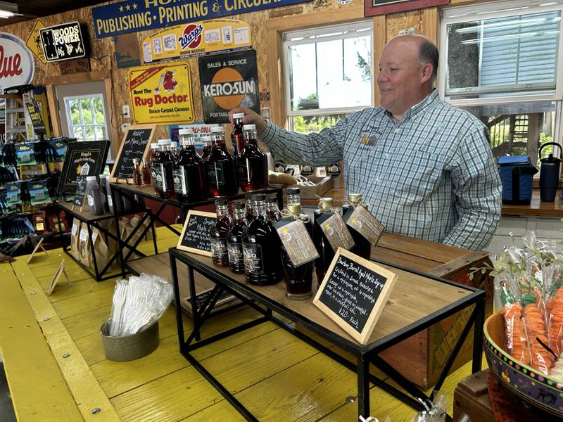 Rob Hough rearranges maple products at Hough's Maple Lane Farm, 3788 N. Mt. Morris Road,  during the sixth annual Back Roads Market on Saturday, Sept. 27, 2025.