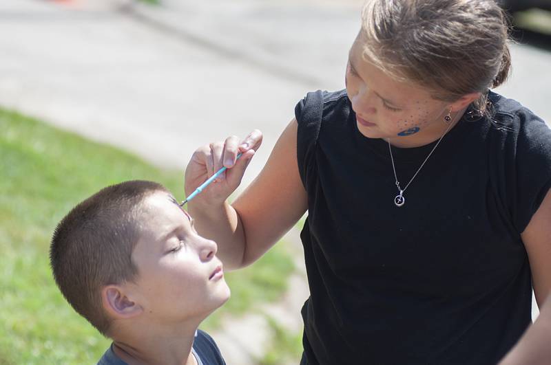 Austin Butters, 10, gets some rad flames painted on his face by Kendal Poff, 9, Thursday during a summer celebration at Coloma Homes in Rock Falls.