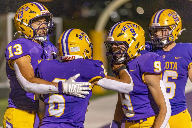 Corbin Ferar's teammates Cam Wasmer (13) and Gavin Evans (9) celebrate Ferar's touchdown against Newman Central Catholic High School during the game at The Jeff Prusator Athletic Complex on September 5, 2025 at Mendota High School.