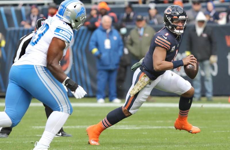 Chicago Bears quarterback Justin Fields scrambles away from Detroit Lions defensive end Josh Paschal during their game Sunday, Nov. 13, 2022, at Soldier Field in Chicago.