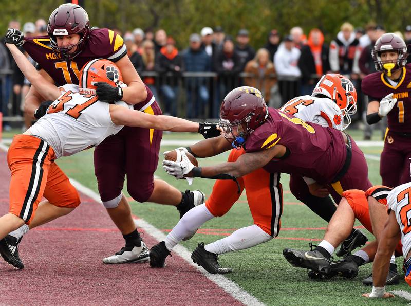 Montini's Jeremiah Peterson stretches the ball over the goal line for a touchdown at teammate Angelo DeSensi (left) blocks Byron's Maddex Draheim during a Class 3A second-round game on November 9, 2024 at Montini Catholic High School in Lombard.