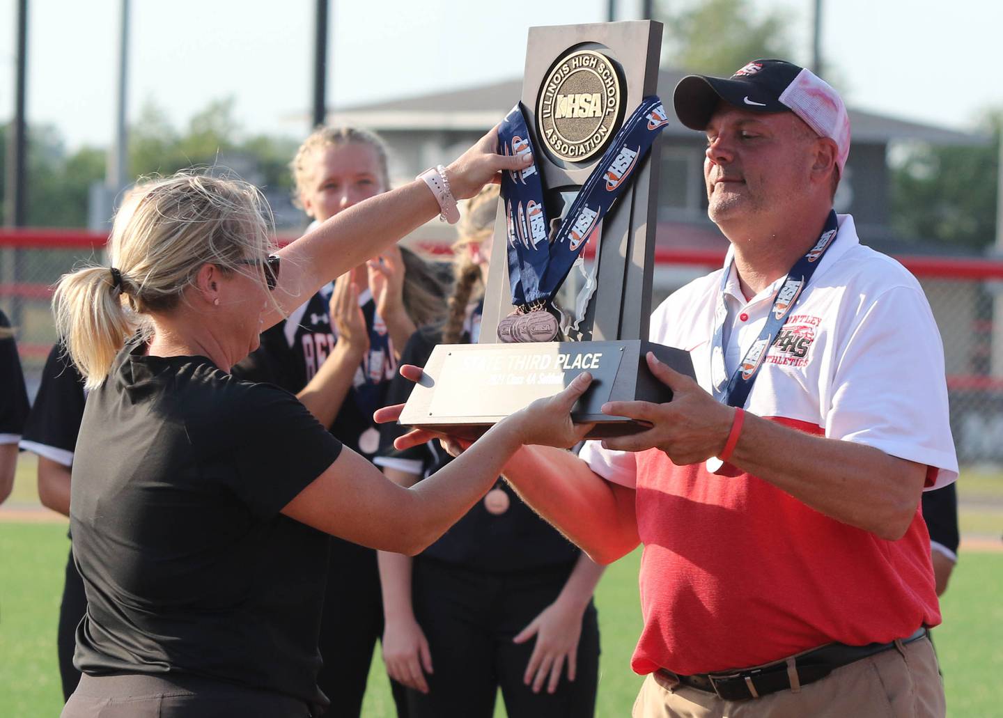 Huntley coach Mark Petryniec accepts the trophy after winning the IHSA Class 4A third-place game June 17 over Minooka at the Louisville Slugger Sports Complex in Peoria.