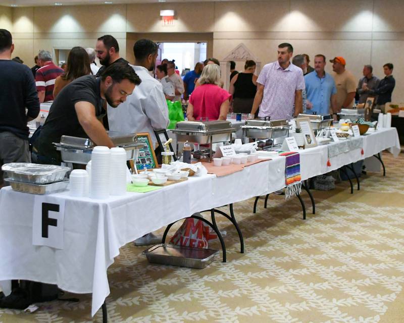 Chefs who participated in CASA DeKalb County's 21st annual 50 Men Who Cook fundraiser wait for community members to sample their creations on Saturday, Aug. 9, 2025, at Northern Illinois University's Barsema Alumni and Visitors Center.