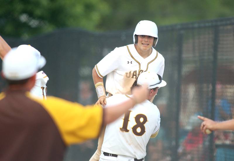 Jacobs’ Luke Gormsen gets a lift from Brandon Helbig after Gormsen scored late in Class 4A Sectional baseball action at Carpentersville Wednesday. The Golden Eagles advanced to Saturday’s title game with a win over Huntley.