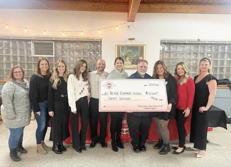 Tim Caruso (fourth from right) and The Kids Equipment Network Board members accept a $20,000 grant from Downers Grove Junior Woman’s Club Board members.