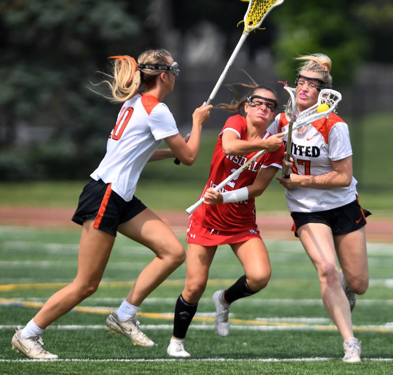 Hinsdale Central’s Peyton Moncrief, middle, draws contact from Crystal Lake Central Coop’s Alivia Nielsen, left, and Ella Trudeau during the third-place game of the girls lacrosse state finals at Hinsdale Central High School on Saturday, June 7, 2025.