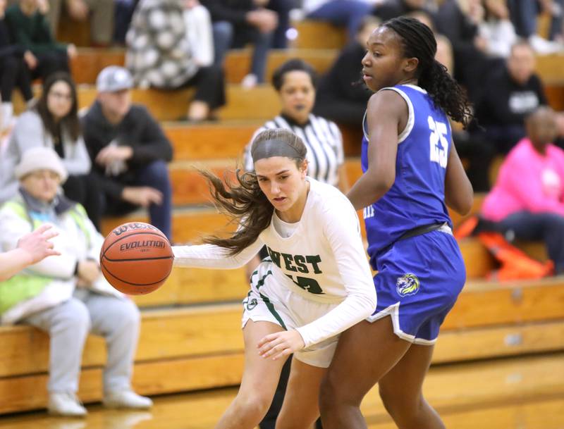 Glenbard West’s Hannah Roberts gets the ball past Lyons Township’s Nora Ezike during a game in Glen Ellyn on Tuesday, Dec. 12, 2023.