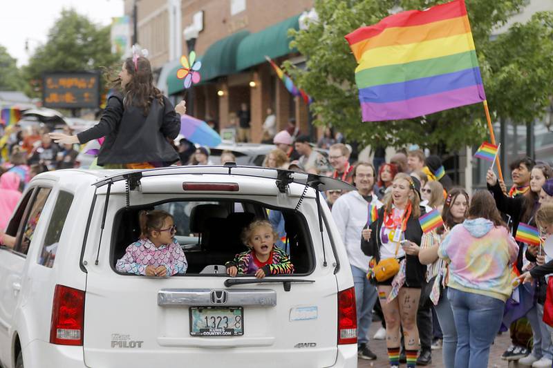 Children enjoy the Woodstock PrideFest Parade from the back of a sports utility vehicale Sunday, June 11, 2023, around the historic Woodstock Square.