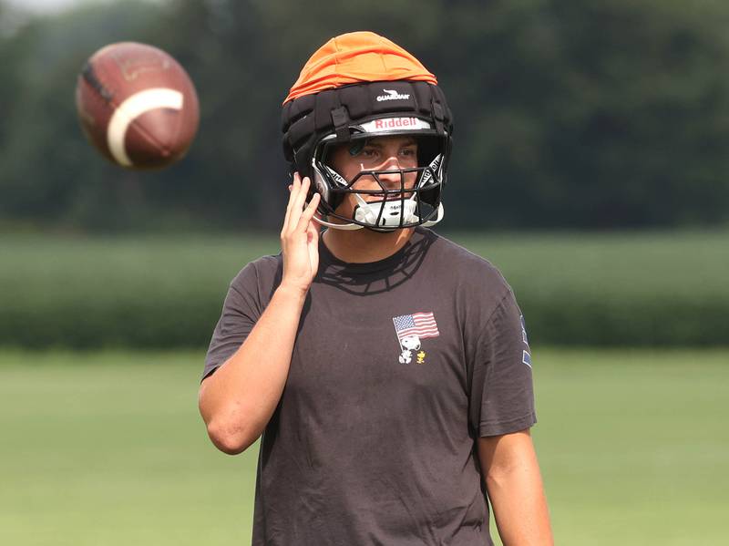 Kaneland’s Jack Parker loosens his chin strap as the ball is thrown back for another play Monday, Aug. 18, 2025, during practice at the school in Maple Park.