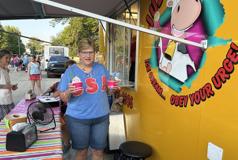 Janic Deets of Polo, serves two ice cream treats to customers from the Just 4 Fun food truck during the Let Freedom Ring block party on  Friday, July 4, 2025 in Mt. Morris.