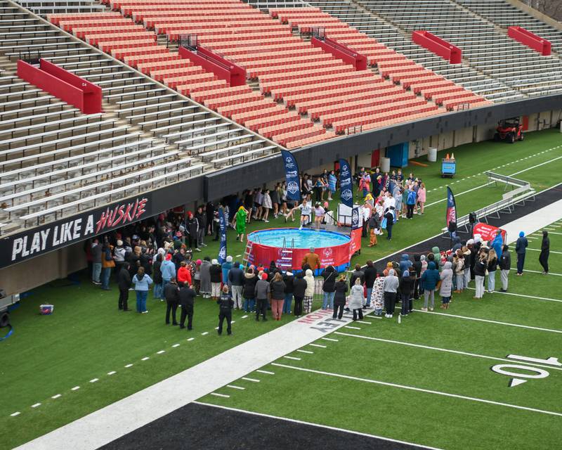 Members of the Alpha Sigma Alpha sorority, who raised the most money as a team, jump in during the Polar Plunge event on Saturday Feb. 21, 2026, while spectators stand pool side to watch them take the plunge hosted at Huskie Stadium in DeKalb.