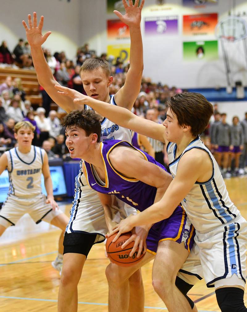 Downers Grove North's Jake Riemer looks for a path to the basket above as Downers Grove South's Daniel Sveiteris (top) and Dominic Marcantelli double team during a crosstown game on Dec. 17, 2022 at Downers Grove South High School in Downers Grove .