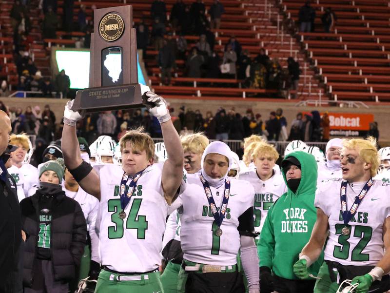 York’s Jimmy Conners holds the state second place trophy with his team after their Class 8A state championship game loss to Loyola Saturday, Nov. 30, 2024, in Hancock Stadium at Illinois State University in Normal.