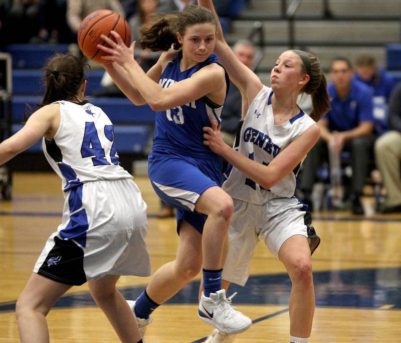 Wheaton North's Claire Hyde (13) tries to get past a pair of Geneva defenders during a game at Geneva on Jan. 4 2020.