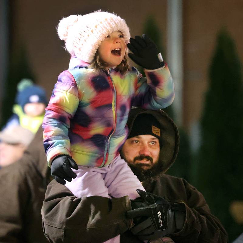 Lyanna Ryder, 4, from DeKalb, gets a boost as she tries to get Santa’s attention Thursday, Dec. 5, 2024, after he arrived in front of the Egyptian Theatre during the DeKalb Chamber of Commerce’s Lights on Lincoln and Santa Comes to Town.