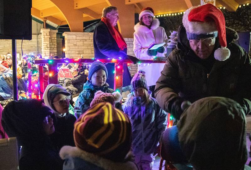 Kids sing along to Christmas carols performed by the Batavia Community Band during the Celebration of Lights at the Batavia Riverwalk on Sunday, Dec. 1, 2024.