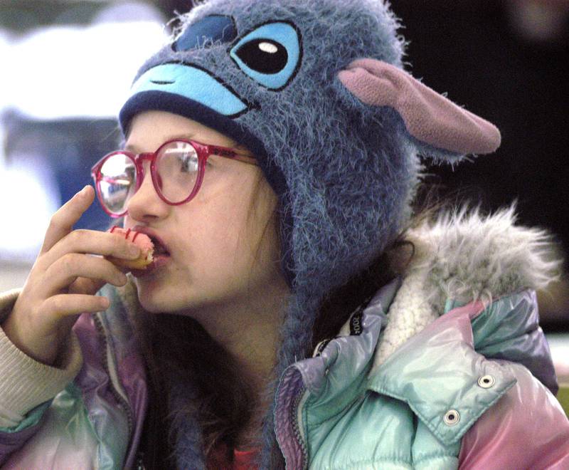 Lyanna Moore grabs a donut before shopping. Whiteside County sheriff's deputies shopped with kids on Saturday, Dec. 13, 2025 at Sterling Walmart.
