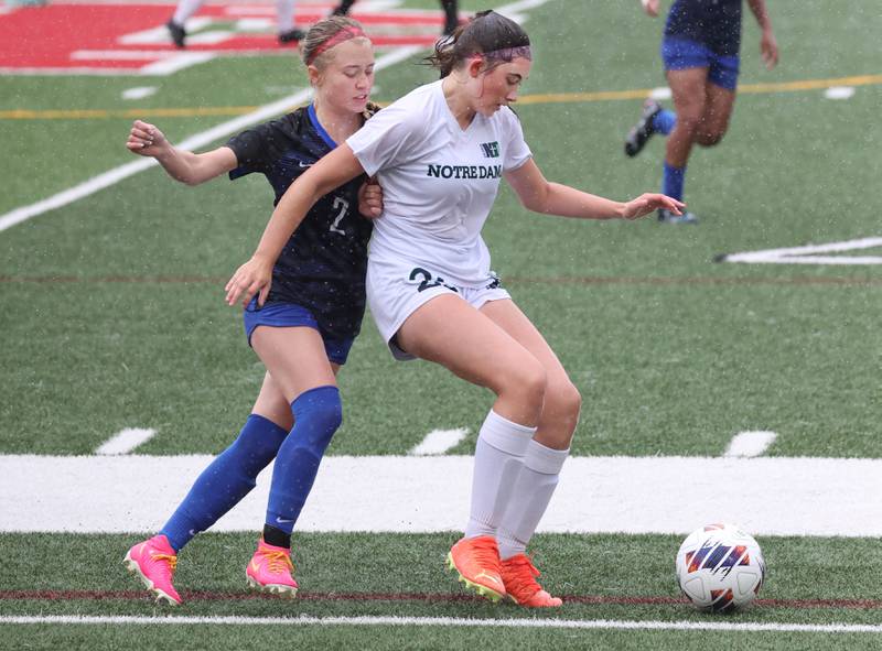 Burlington Central's Ellie Elders (left) tries to fight through Peoria Notre Dame's Ryleigh Bennett during their third place game Saturday, June 1, 2024, at the IHSA Class 2A state soccer finals at North Central College in Naperville.