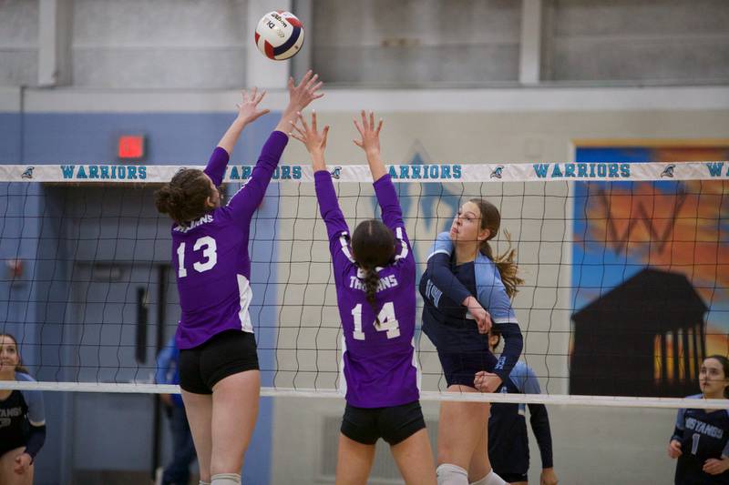 Downers Grove South's Jennifer Curran spikes the ball past Downers Grove North's Nora Benjamins (13) and Ellery Cabaj at the Class 4A Willowbrook Sectional Final on Thursday, Nov.7,2024 in Villa Park.