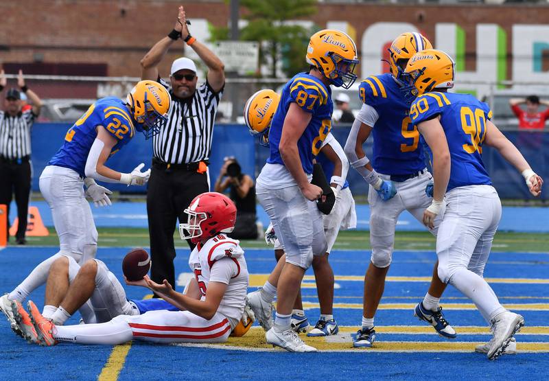 The Lyons Township defense celebrates in the end zone after stopping Hinsdale Central’s Micah Drescher (16) for a loss during a game on September 20, 2025 at Lyons Township High School in LaGrange.