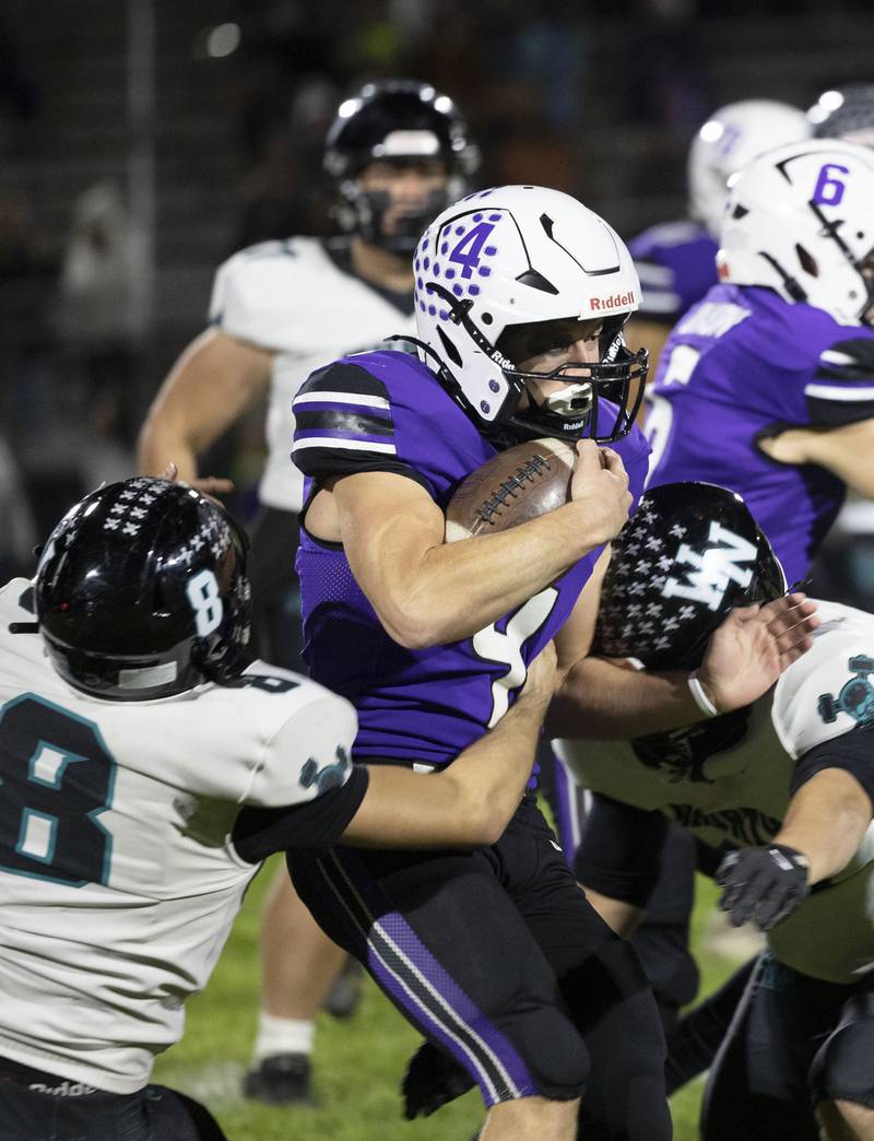 Dixon’s Landon Knigge fights through Woodstock North tacklers Friday, Oct. 31, 2025, in the Class 4A football first round playoffs.