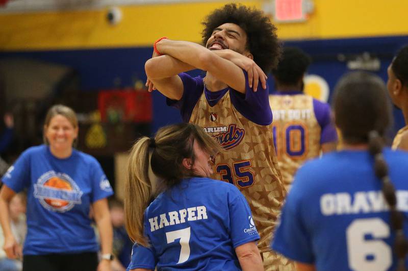 Harlem Wizards player Tyler Cronk (Sky-Rise) leans in to hug  Douglas Elementary kindergarten teacher Stacey Harper during the Harlem Wizards event on Tuesday, Oct. 28, 2025 in Pannebaker Gymnasium at Logan Jr. High School in Princeton.