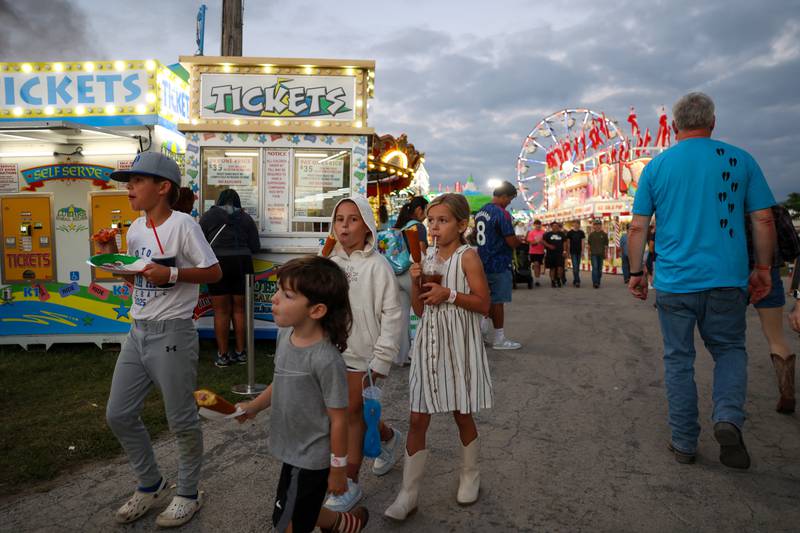 Children enjoy fair goodies as they walk the grounds during the Will County Fair on Aug. 21, 2025.