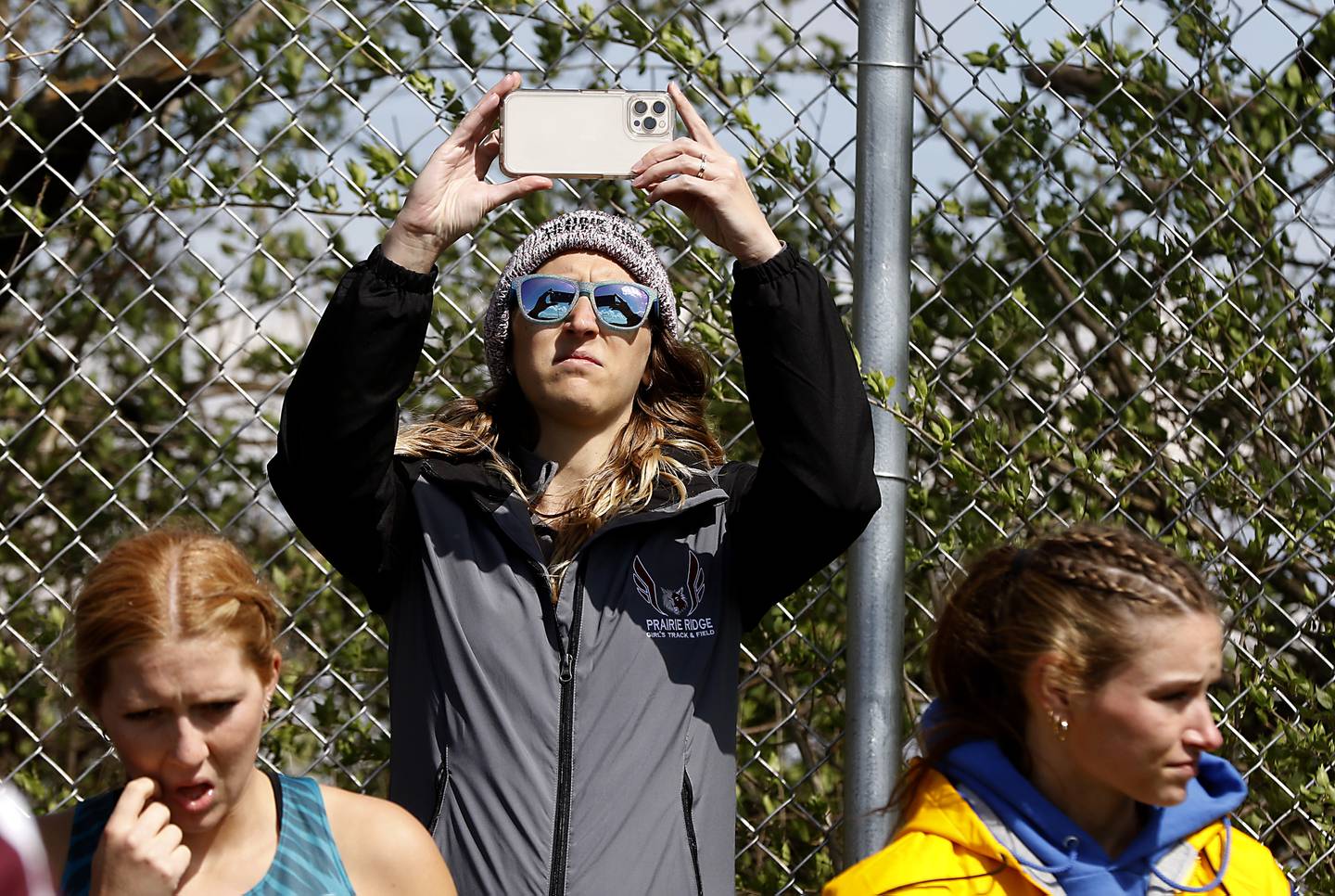 Prairie Ridge track coach Sarah Long records the long jump of an athlete Friday, April 21, 2023, during the McHenry County Track and Field Meet at Cary-Grove High School.