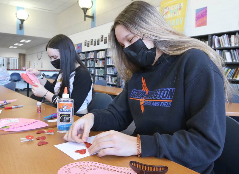 Mirela Music, (left) a freshman at Genoa-Kingston High School, and her sister sophomore Medina Music make Valentines Day cards Tuesday, Jan. 25, 2022, in the library at the school. The cards students are making will be part of “Valentines for Seniors,” a card drive for local seniors living in residential care facilities, sponsored by State Representative Jeff Keicher, R-Sycamore, and State Senator Dave Syverson R-Rockford.