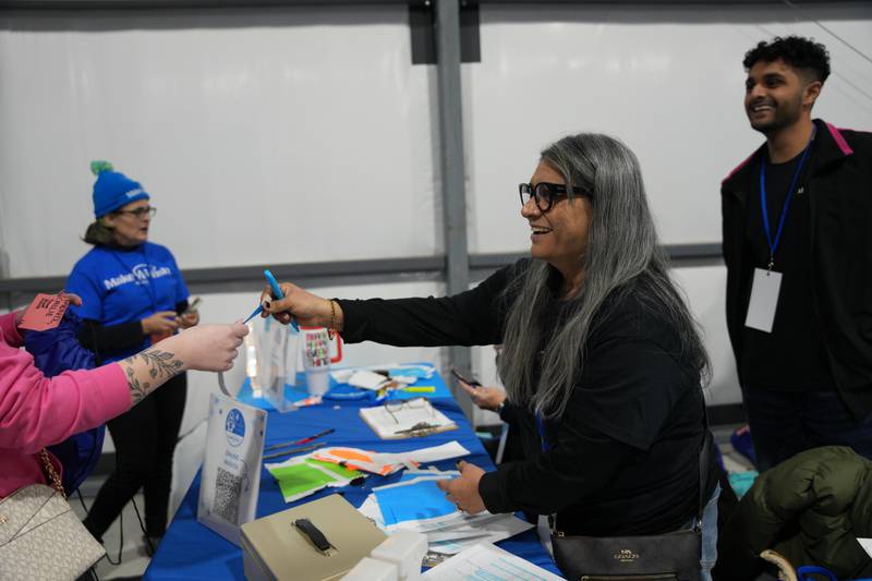 From left, Wendy Cherry of Hillside, Sejal Amin of Bloomingdale and Krish Amin of Hanover Park assist Penguin Plunge attendees with event registration on Saturday, Jan. 25, 2025 at Skydive Chicago in Ottawa.