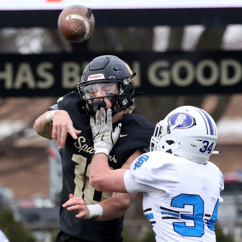 Sycamore's Burke Gautcher throws a pass just before the hit by St. Francis' Will Alt Saturday, Nov. 16, 2024, during their Class 5A quarterfinal game at Sycamore High School.