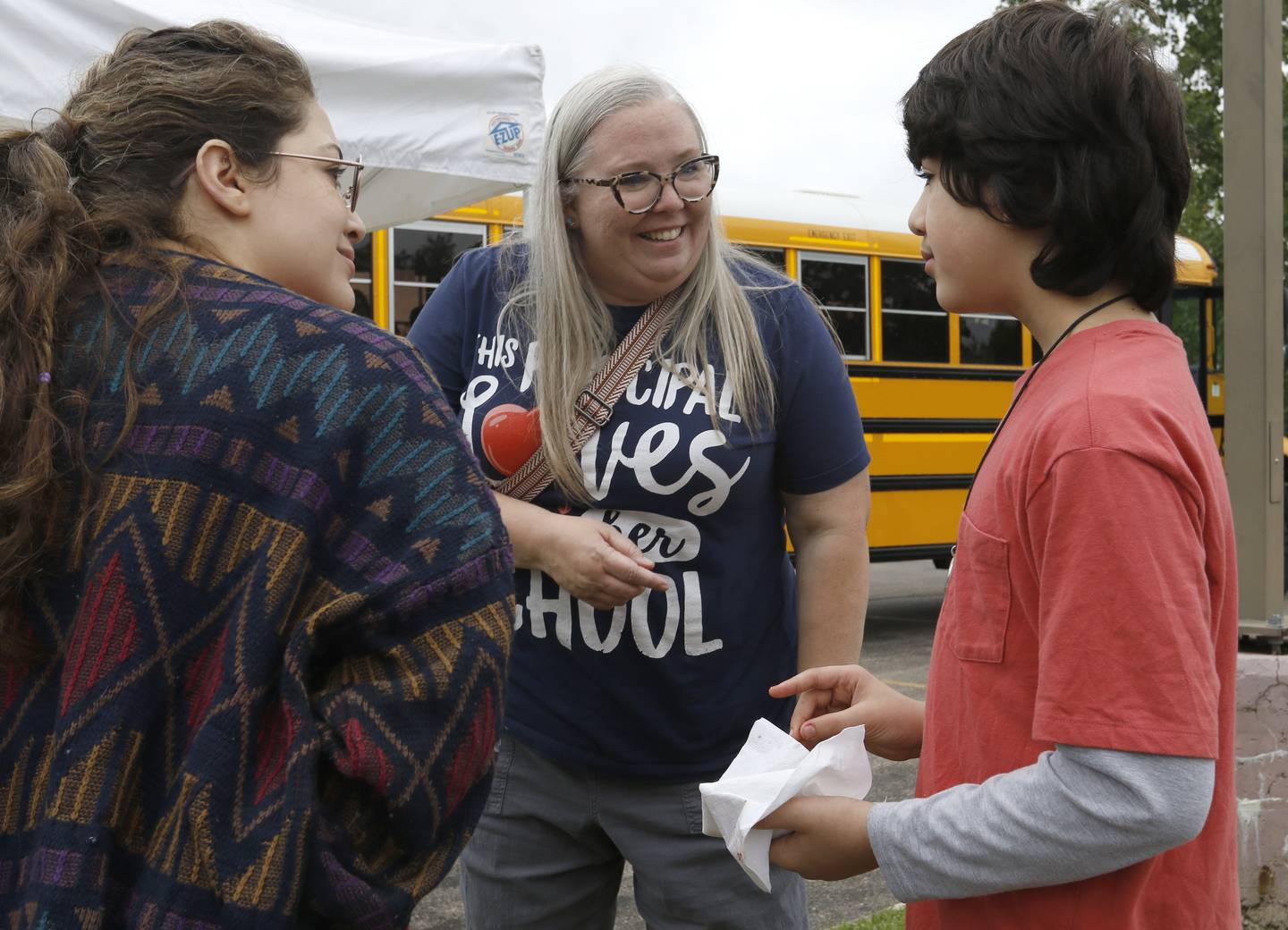 Northwood principal Bethany Hall talks with Ian Mejdouli and his mom, Tavena, during a Woodstock School District 200 Back to School Coming to You event at Sheila Street Apartments on Tuesday, Aug. 6, 2024. The location was one of twelve stops on the tour that gave out backpacks and school supplies, provided registration help and computer repair.