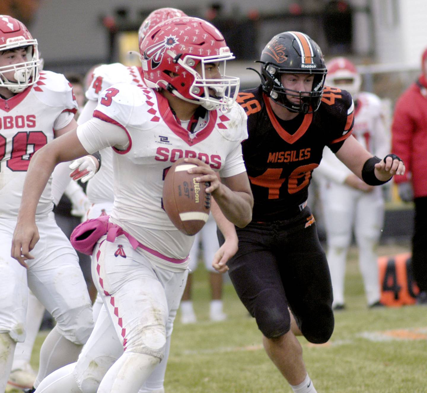 South Beloit's Kaden Cook is pursued by Milledgeville'S Karter Livengood. The Milledgeville Missiles defeated the South Beloit SoBos 22-6 in Round 2 of the I8FB playoffs. The game took place at Milledgeville on Saturday, November 8th, 2025