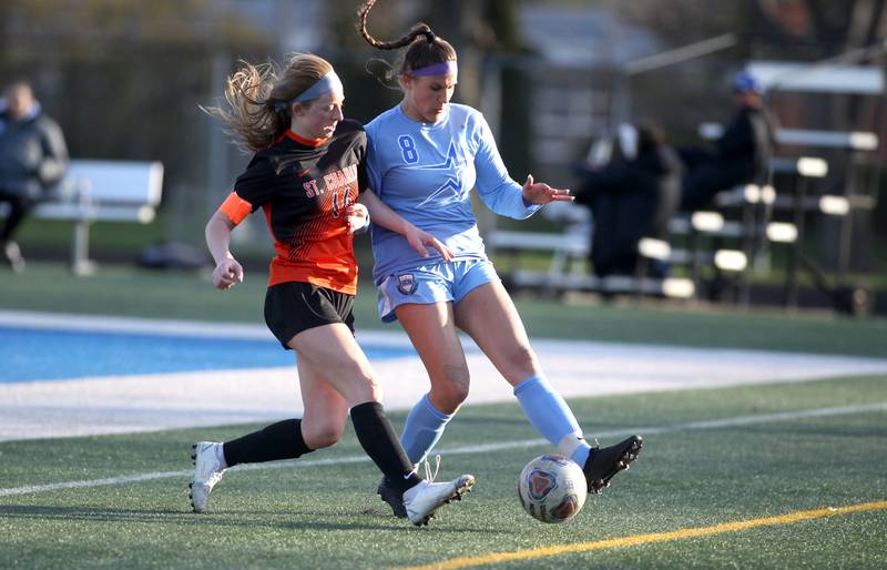 St. Charles East’s Libby Thomas and St. Charles North’s Sophia Hein (8) go after the ball during a Tri-Cities Night game at Geneva High School on Tuesday, April 26, 2022.