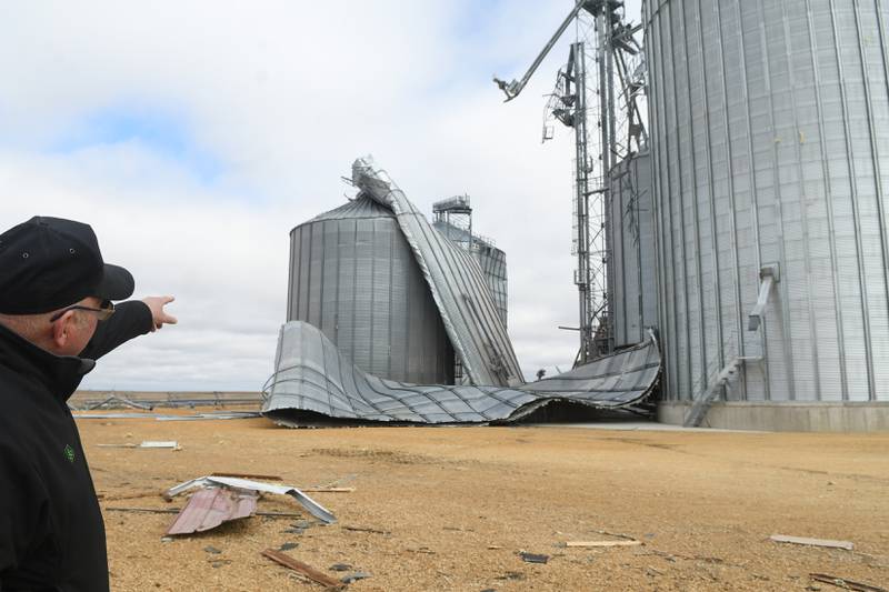 Jim Ludwig of Lanark points to the 125-foot grain bins that were damaged during Friday's storm along Illinois 64 about 5 miles east of Lanark.