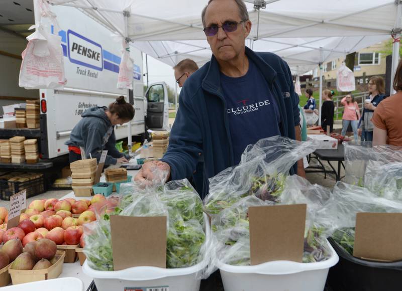 Robert Pollow of Downers Grove buys lettuce during the Downers Grove Farmers Market Saturday May 13, 2023.