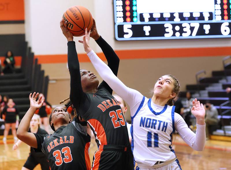 DeKalb’s Kezaria Mitchell grabs a rebound over Wheaton North's Adeline Sutton during their Class 4A regional game Monday, Feb 12, 2024, at DeKalb High School.