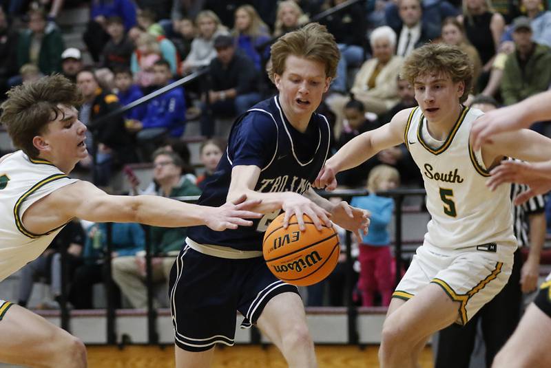 Cary-Grove's AJ Berndt (center) tries to drive the lane against Crystal Lake South's Nick Stowasser (left) and Carson Trivellini (right) during the IHSA Class 3A Prairie Ridge Regional championship basketball game on Friday, Feb. 28, 2025, at Prairie Ridge High School in Crystal Lake.