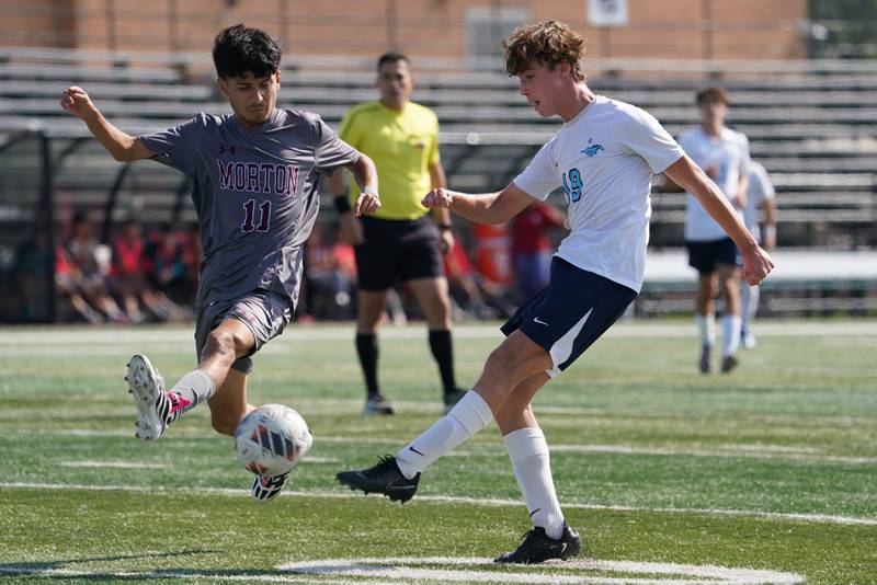 Downers Grove South's Sebastian Sztafa (19) shoots the ball against Morton’s David Perez (11) during a soccer match at Morton High School in Berwyn on Saturday, Oct. 5, 2024.