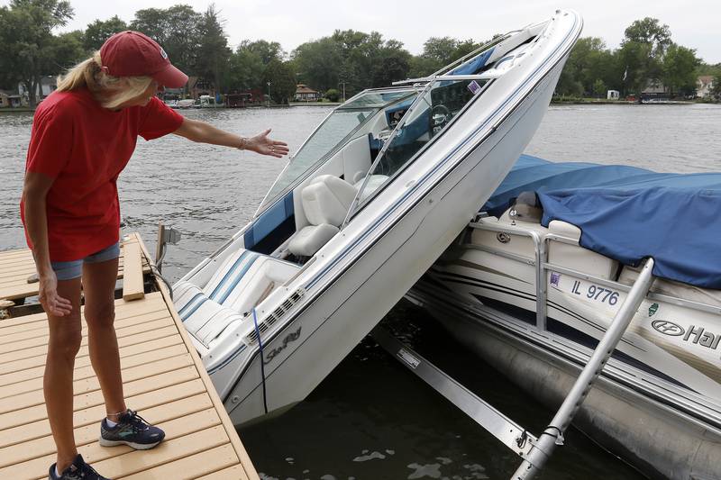 Homeowner Pam Petrucci, of McHenry, shows the damage to her dock and pontoon on Friday, July 16, 2021 in McHenry.  Petrucci said a boat crashed into her dock, launching it atop her pontoon shortly after midnight Friday. Petrucci said she hopes the crash will be cleared up before the traffic on the river picks up over the weekend for fear of excessive wakes sinking her boat.